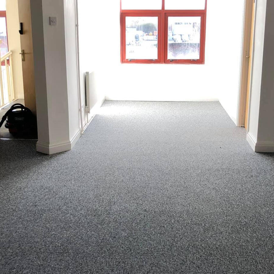 Modern grey carpet tile flooring installed in a bright open‑plan office space, offering a durable, easy‑to‑maintain modular solution for high‑traffic commercial environments.